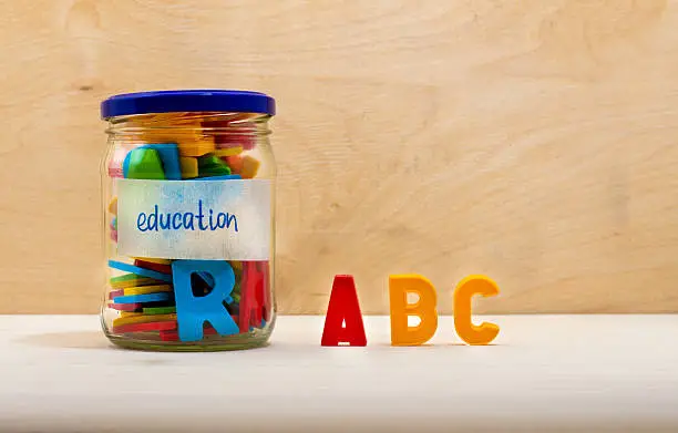 Concept of education. Colorful alphabet in a glass jar