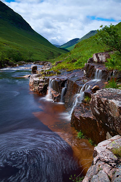 Glen Etive Scenic Scottish Highlands The River Etive flows down Glen Etive, deep in the Scottish Highlands. A long exposure captures the water swirling as it makes its way downstream. etive river photos stock pictures, royalty-free photos & images