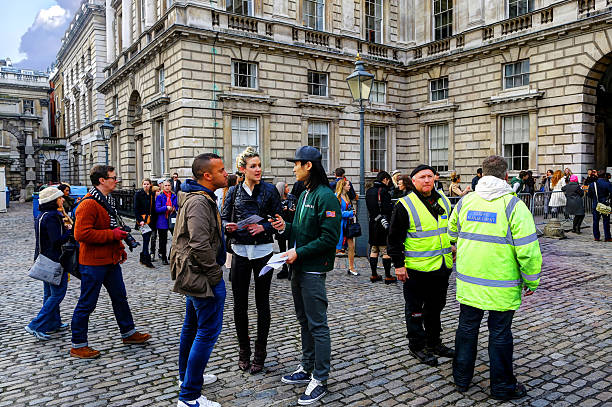 London Fashion Week London, United Kingdom - October 13, 2012: Crowd of people next to two security guards in Somerset House for London Fashion Week.  london fashion week stock pictures, royalty-free photos & images