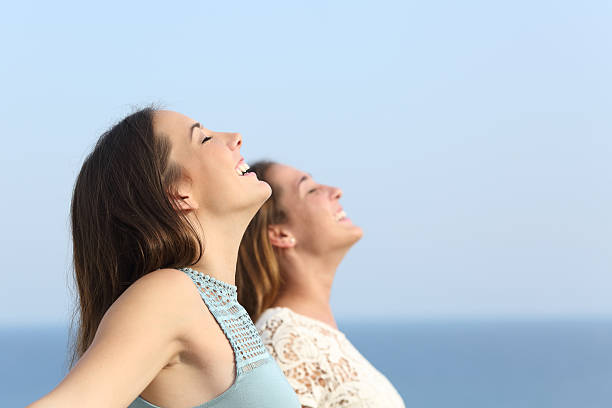 istock Two girls breathing deep fresh air on the beach 493657516