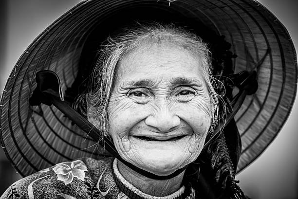 istock Old friendly woman with vietnamese straw hat 493658382