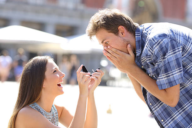 Proposal of a woman asking marry to a man Proposal of a woman asking marry to a man in the middle of a street pleading photos stock pictures, royalty-free photos & images