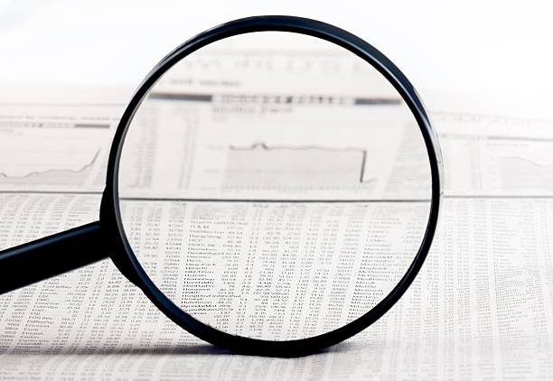 istock financial data see through lens of loupe on newspaper 493658782