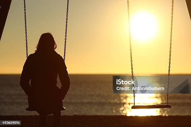 Photo libre de droit de Solitaire Solitaire Femme Regardant Le Coucher De Soleil En Hiver banque d'images et plus d'images libres de droit de Tristesse