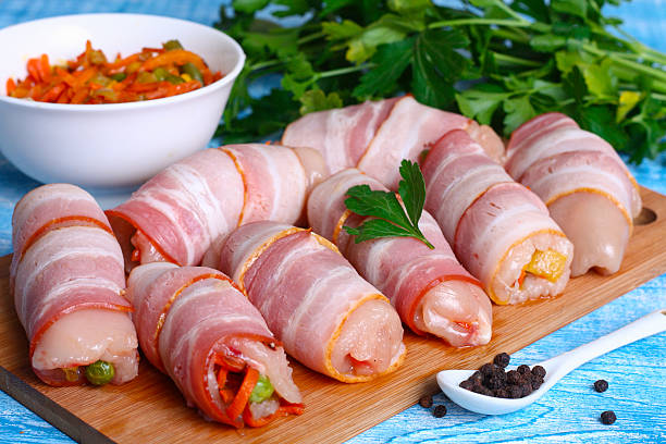 istock Raw chicken rolls stuffed with vegetables wrapped in bacon 493659200