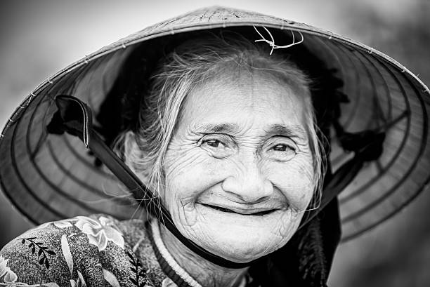 istock Old friendly woman with vietnamese straw hat 493659400