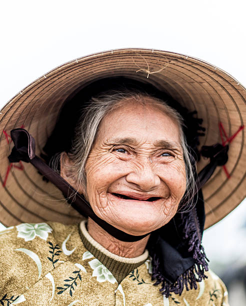 istock Old friendly woman with vietnamese straw hat 493659558