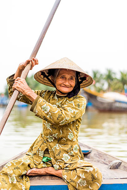 istock Old friendly woman with vietnamese straw hat 493660576