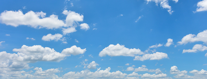 Beautiful blue sky with with fluffy white clouds, background with copy space, full frame horizontal composition