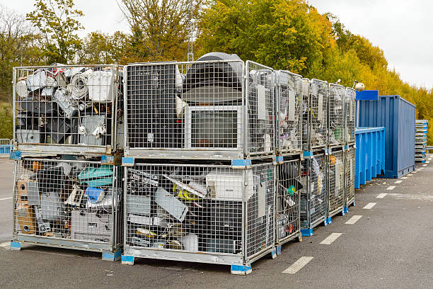 Waste separation Netted bins full of discarded electronics waste waiting to be transported to the recycle plant for further processing. Blue containers in background. e waste photos stock pictures, royalty-free photos & images
