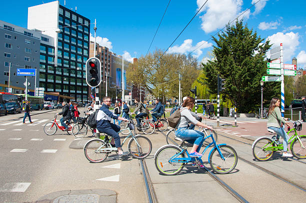 Undefined people cycle on Amsterdam street, the Netherlands. stock photo