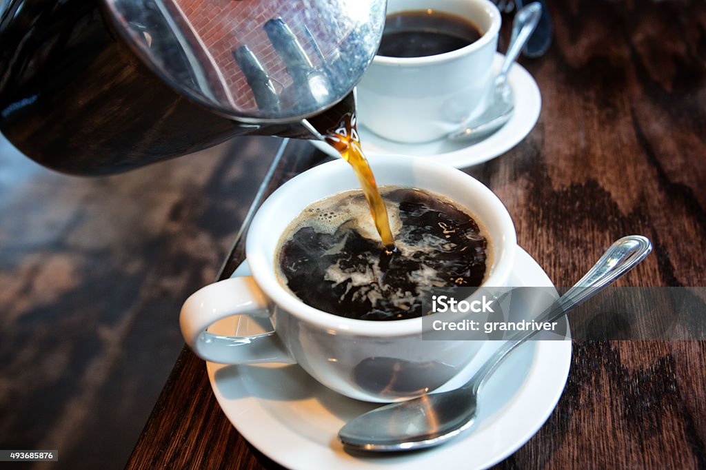 Hot Coffee from a French Press Fresh hot coffee being poured into a cup from a stainless steel french press in a trendy cafe Coffee - Drink Stock Photo