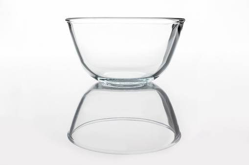 Glass transparent bowl on white background from side with reflection