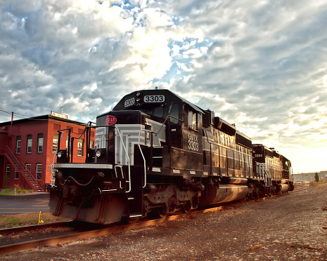 Solvay, New York, USA. October, 22,2015. The Fingerlakes Railway locomotive parked on the railway tracks in front of Chinatown Furniture Store, in early morning