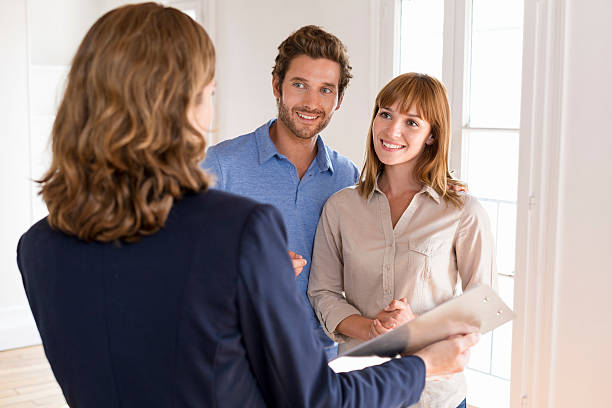 istock Young couple visiting apartment with real estate agent 493688008