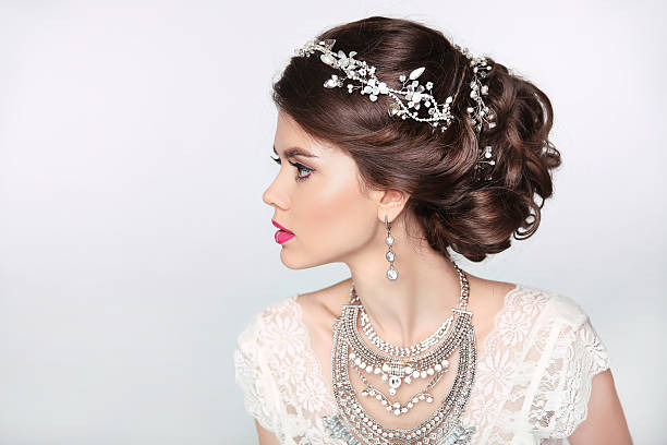 Beautiful elegant girl model with jewelry, makeup and retro hair Beautiful elegant girl model with jewelry, makeup and retro hair styling. Isolated on studio background. hairstyle bride jewelry women stock pictures, royalty-free photos & images