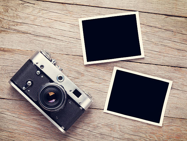 Vintage film camera and two blank photo frames Vintage film camera and two blank photo frames on wooden table. Top view two objects photos stock pictures, royalty-free photos & images