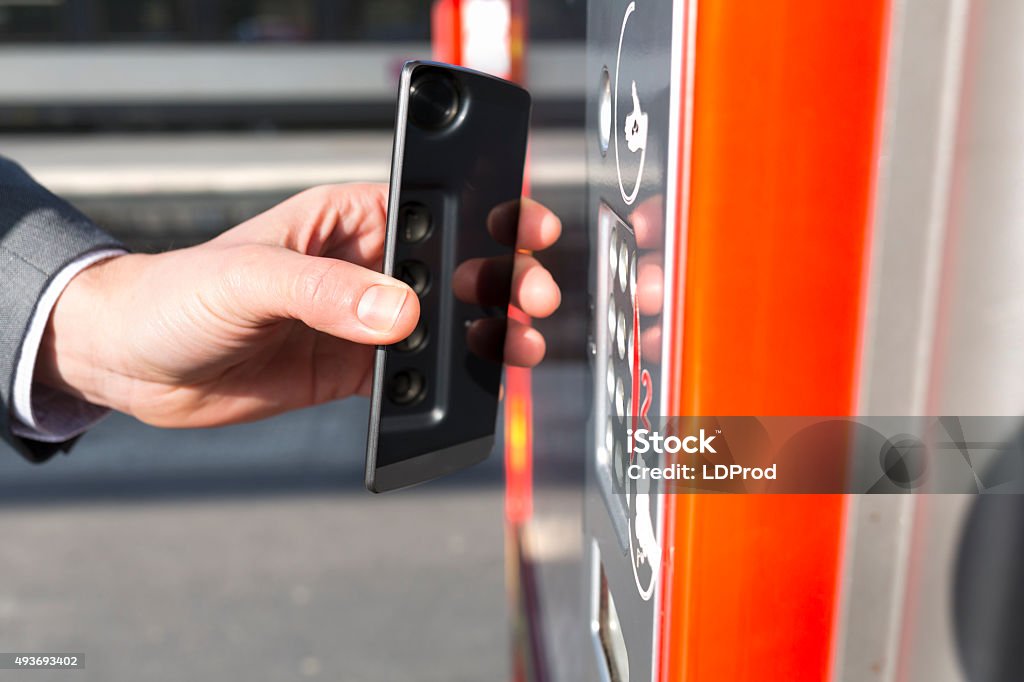 Hombre paga el transporte boleto con teléfono móvil en la plataforma - Foto de stock de Aparcamiento libre de derechos