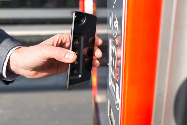 uomo carico trasporto biglietto con cellulare sulla piattaforma - biglietto di parcheggio foto e immagini stock