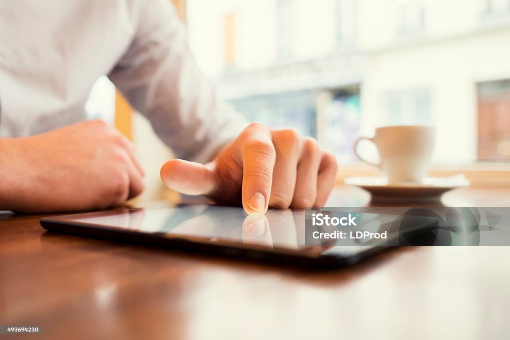 Man in a bar using tablet pc. Window background. Business man with digital tablet  restaurant Digital Tablet Stock Photo