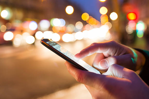 istock Man using his Mobile Phone in the street, bokeh 493694506
