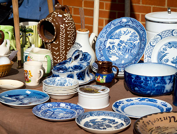 Fakenham, Norfolk, England - September 24, 2015: A market stall selling old china. There is a variety of ages, types and styles including plates, jugs, mugs, dishes, bowls and an inhaler, seen on a bright and sunny early autumn day.