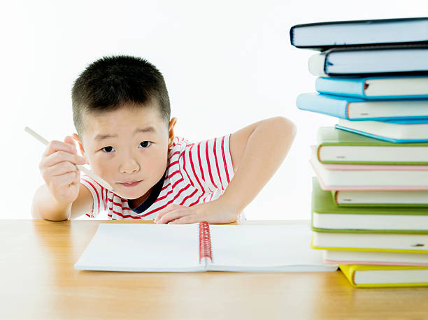 istock Little asian boy with stack of books 493695342