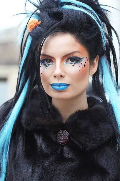 Portrait of young beautiful punk dark girl over urban landscape. Makeup. Hairstyle.