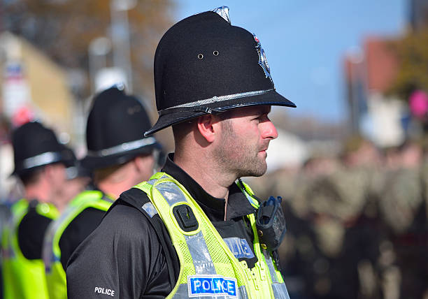 British Police on duty in numbers St Neots, Cambridgeshire, England - October 20, 2015: British Police on duty in numbers at a military parade in St Neots Cambridgeshire all wearing high vis jackets and helmets. cambridgeshire photos stock pictures, royalty-free photos & images