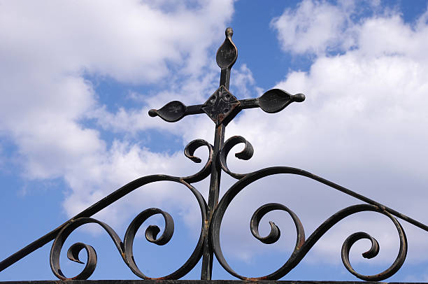 istock Wrought iron cross on fence in the sky 493698026