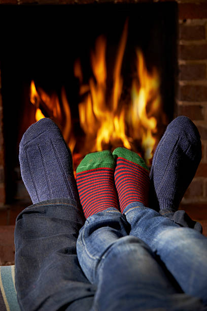 istock Father And Child Wearing Socks Warming Feet By Fire 493698836