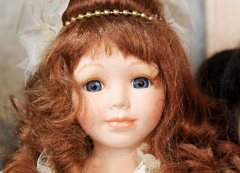 A beautiful antique doll is photographed at an antique shop.