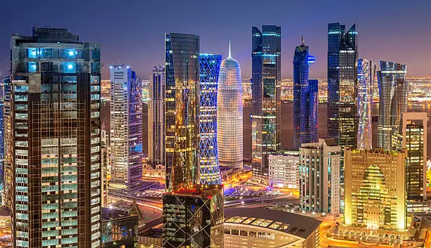Modern, illuminated urban skyscrapers in the city of Doha at night. Panoramic Aerial View of Downtown Doha, Qatar