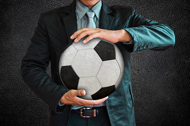 istock Businessman holding the ball on a black background. 493709675