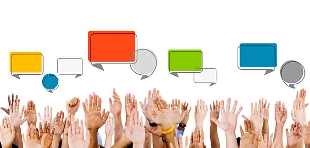 Photo of Multiethnic Hands Raised with Speech Bubbles