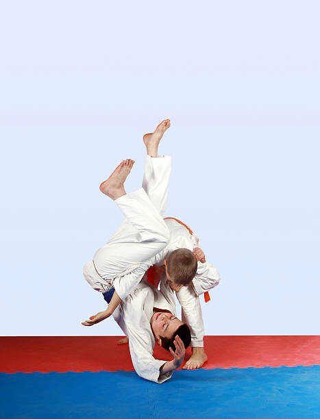 istock Performing throw athlete in kimono with orange belt 493711253