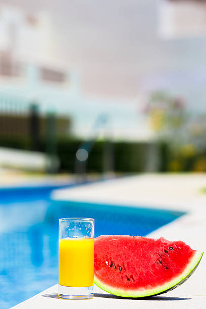 istock Summer theme: watermelon and orange juice on green grass 493711354
