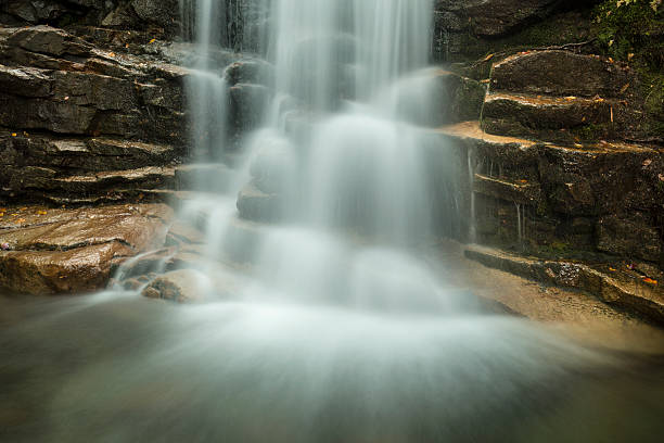 Silky water of Stairs Falls in Franconia Notch, New Hampshire. Long exposure of Stairs Falls, one of three waterfalls on Dry Brook, seen along the Falling Waters Trail in Franconia Notch of the White Mountains National Forest in northern New Hampshire. franconia new hampshire stock pictures, royalty-free photos & images