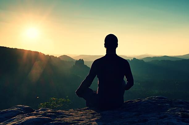 istock Hiker in squatting position on a rock, enjoy dybreak  scenery 493713256