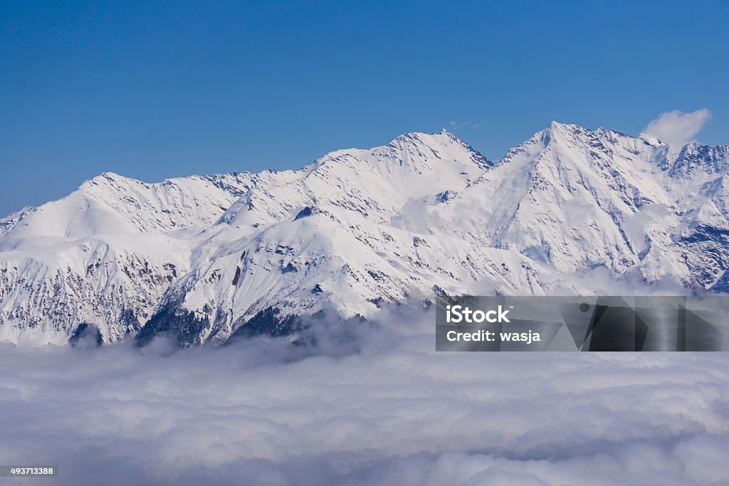 View on mountains and blue sky above clouds, Krasnaya Polyana View on winter snowy mountains and blue sky above clouds, Krasnaya Polyana, Sochi, Russia 2015 Stock Photo