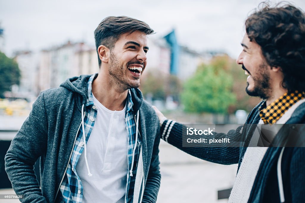 Men Smiling young men at urban scene Discussion Stock Photo