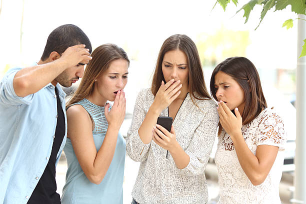 quatro preocupados amigos assistindo telefone inteligente - middle eastern ethnicity teenage girls women sadness - fotografias e filmes do acervo