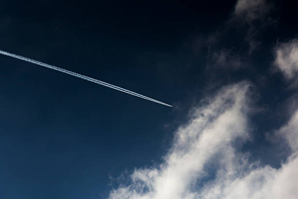 Chemtrail on a blue sky stock photo