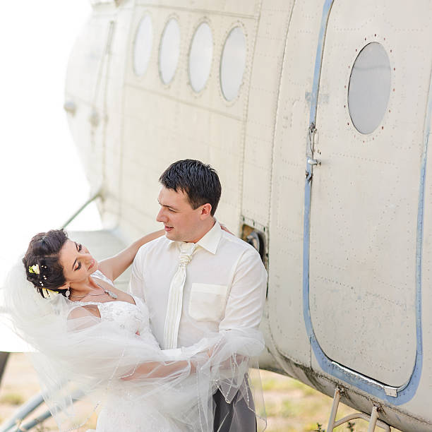 istock Wedding summer couple together posing against airplane. 493718010