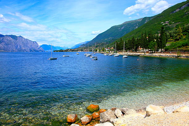 船やヨットイタリアのターコイズ色の半透明ガルダ湖のパラダイス、マルチェージネ地方 - lake garda sunset blue nautical vessel ストックフォトと画像