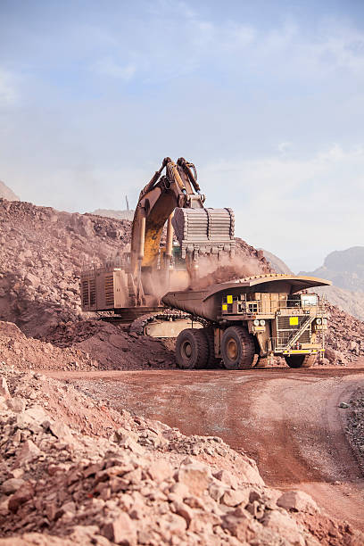 Huge Excavator. Mining Loading of copper ore on very big dump-body truck copper mine photos stock pictures, royalty-free photos & images