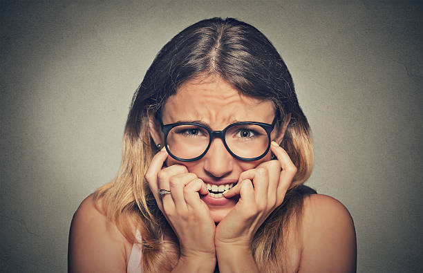 istock stressed anxious woman in glasses biting fingernails 493725184
