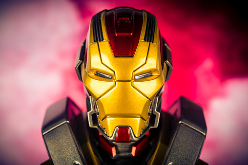 Notre Dame De Lile Perrot, Canada - October 22, 2015: A vertical studio headshot of a Marvel Comics figurine Iron Man, from Iron Man 3. The figurine is shot against a red  background with smoke