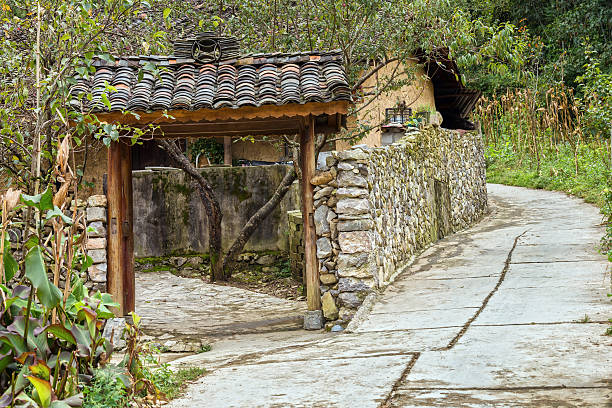 Idyllic beauty of ancient stone houses with stone fence, the road leading to the house was turned from a rural road with porch roofs, wood columns. This is the rustic character of the house in Ha Giang, Vietnam