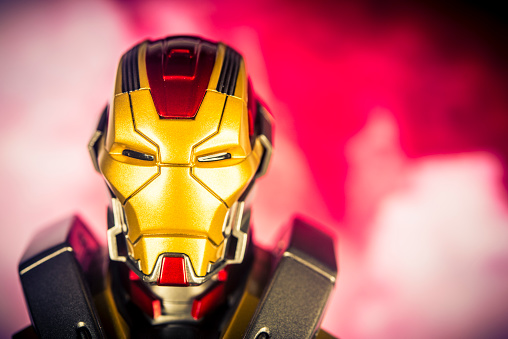 Notre Dame De Lile Perrot, Canada - October 22, 2015: A vertical studio headshot of a Marvel Comics figurine Iron Man, from Iron Man 3. The figurine is shot against a red  background with smoke